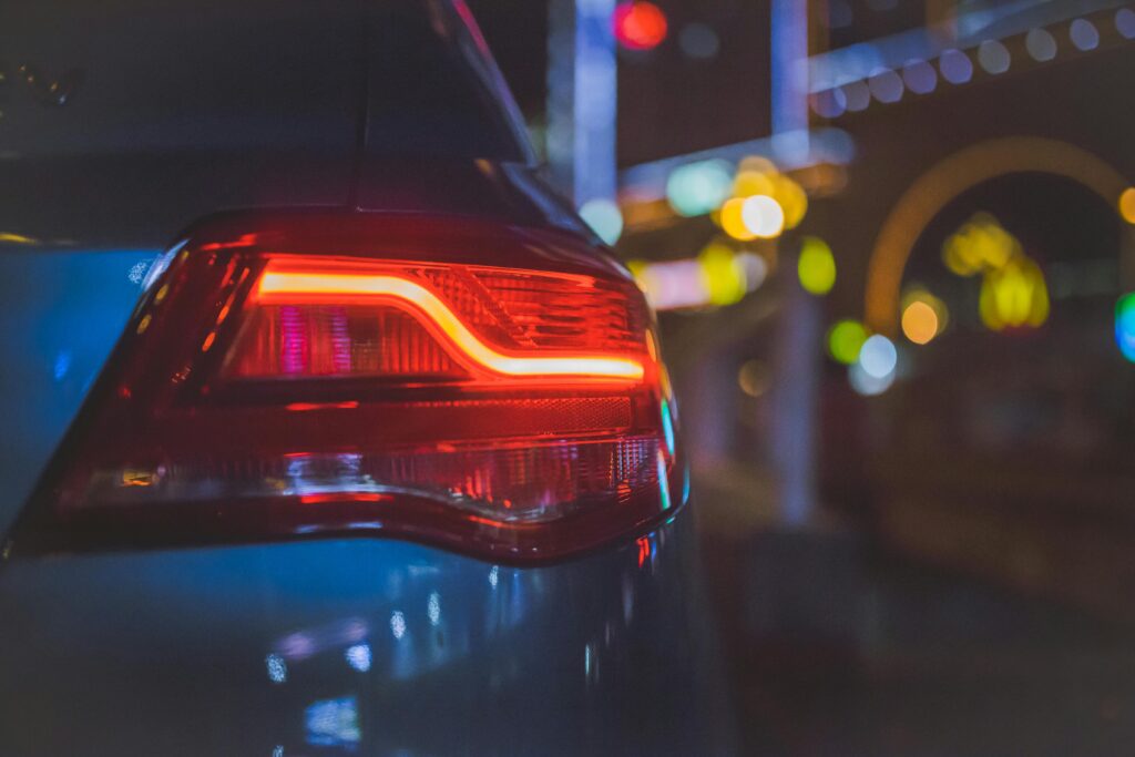 pexels-photo-191238-191238 Close-up of a car's tail light with colorful bokeh background in an urban night setting.