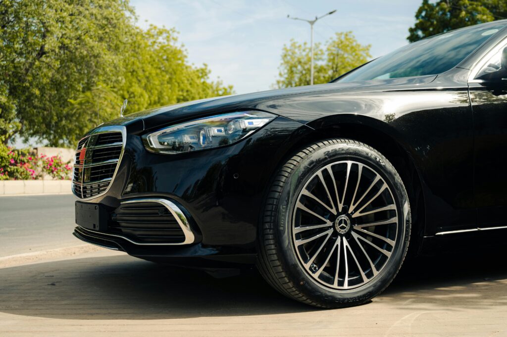 pexels-photo-31040129-31040129 Sleek black Mercedes Benz parked on a sunny outdoor street, showcasing luxury design.