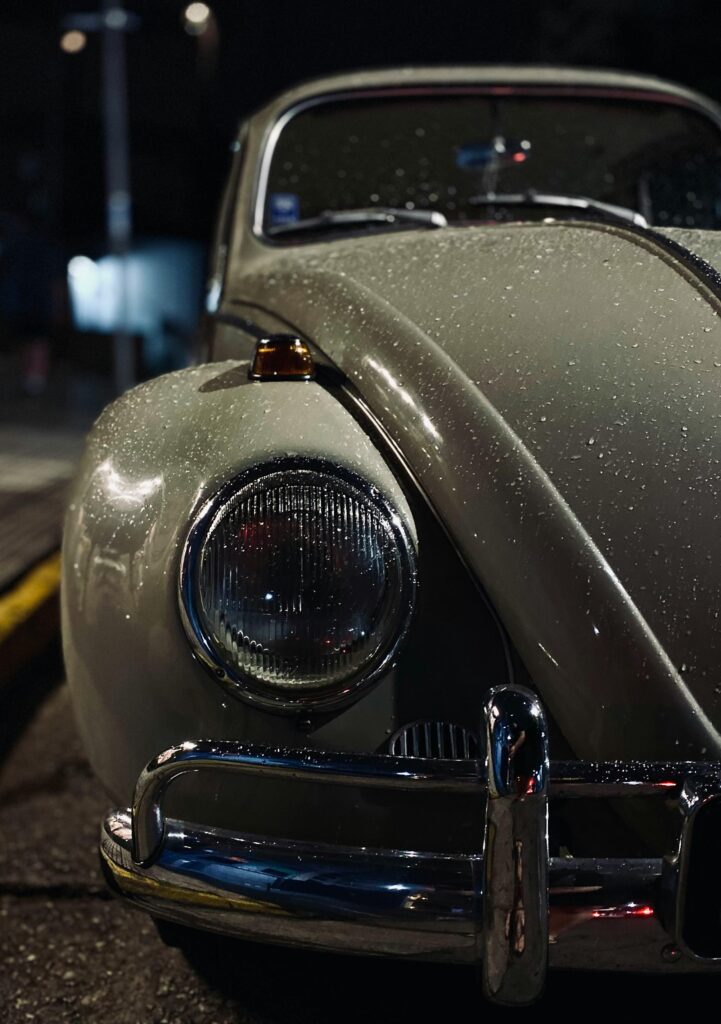 pexels-photo-31080677-31080677 Vintage Volkswagen Beetle parked on a wet street at night in São Paulo, Brazil.
